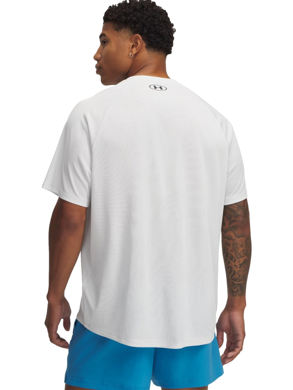 Hombre vistiendo una camiseta deportiva de manga corta color gris de la marca Under Armour.