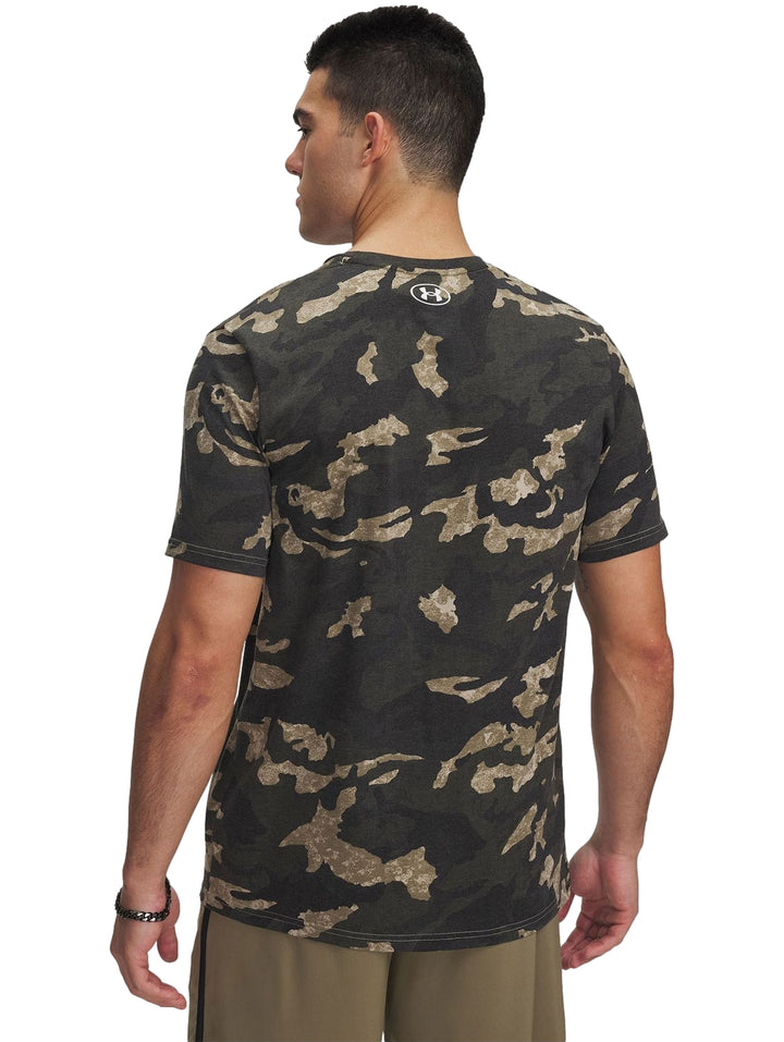 Hombre vistiendo camiseta deportiva de manga corta con estampado de camuflaje en tonos marrón y verde.