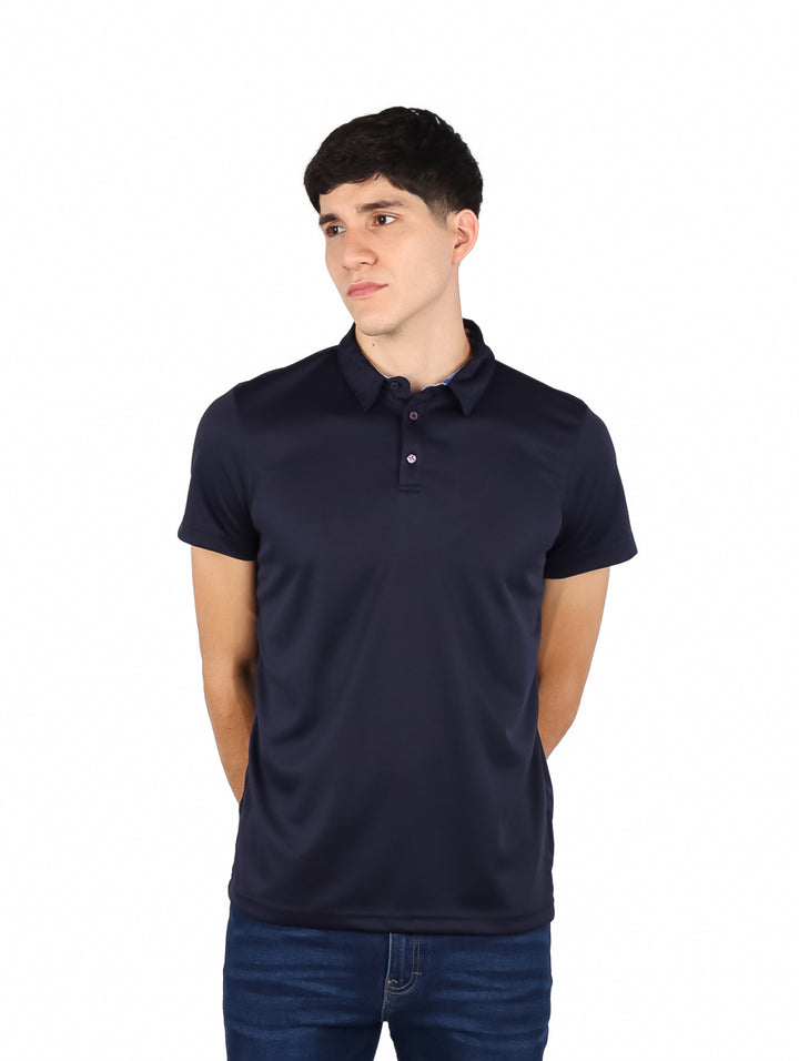 Hombre vistiendo una playera polo de color azul marino con cuello y manga corta.