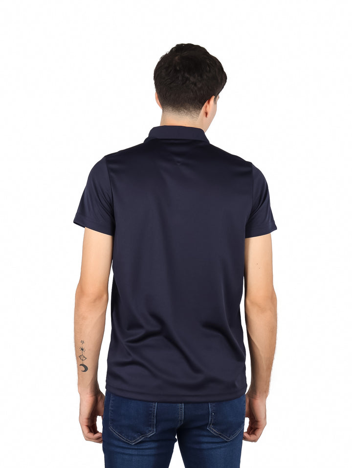 Hombre vistiendo una playera polo de color azul marino con cuello y manga corta.