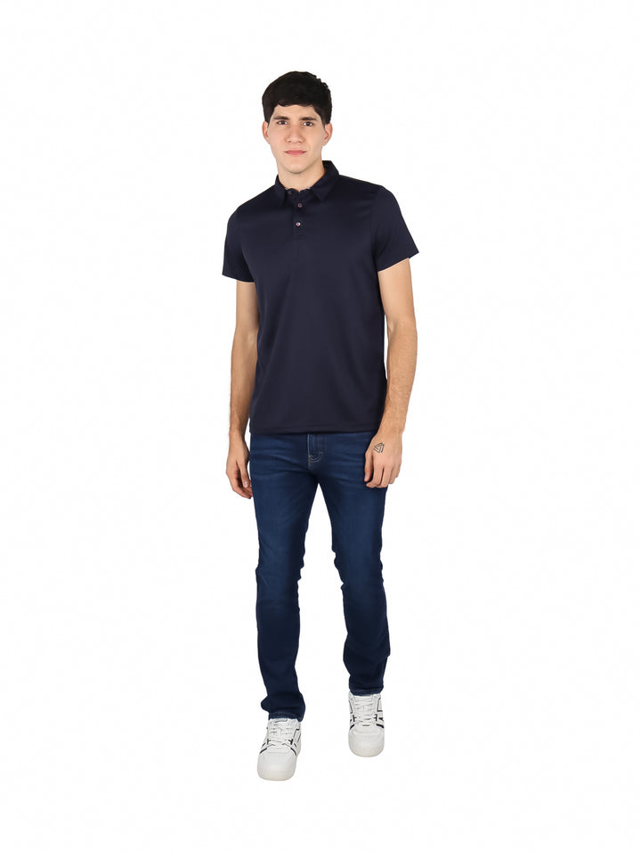 Hombre vistiendo una playera polo de color azul marino con cuello y manga corta.