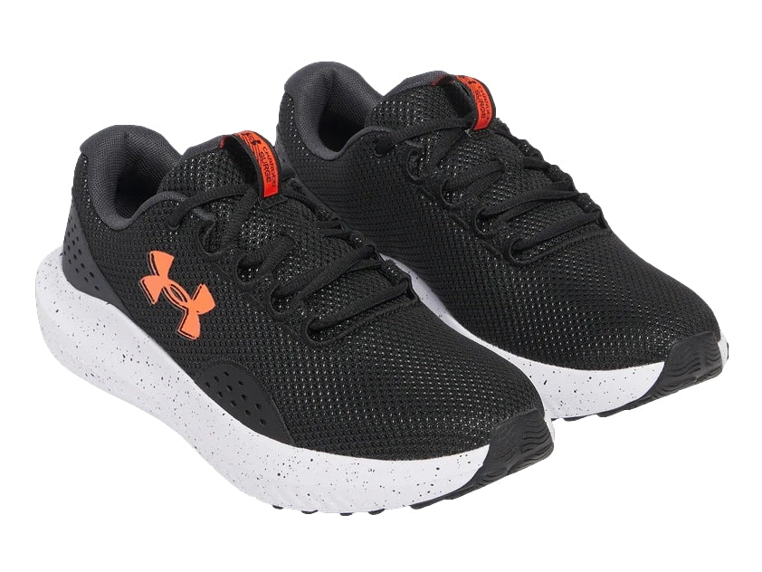 Tenis deportivos Under Armour color negro con suela blanca y logotipo naranja en el costado.