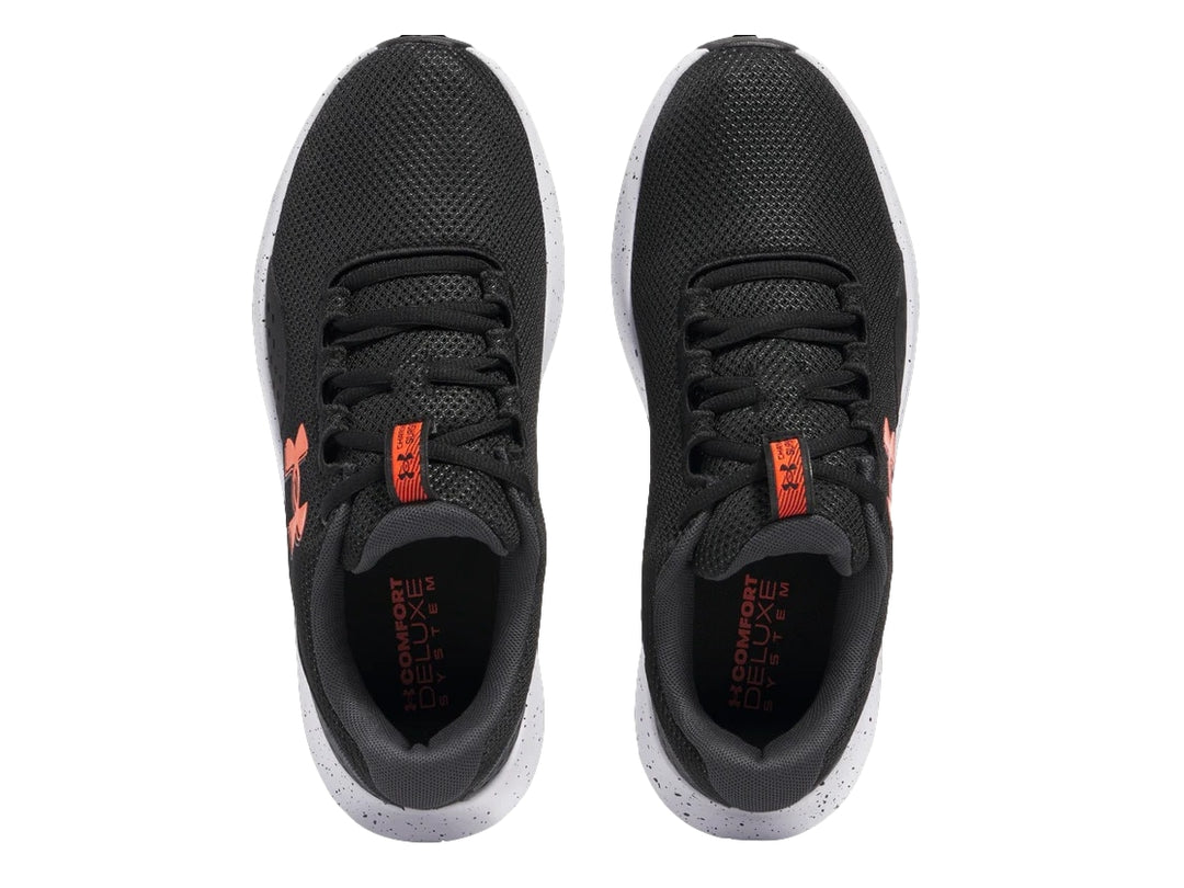 Tenis deportivos Under Armour color negro con suela blanca y logotipo naranja en el costado.