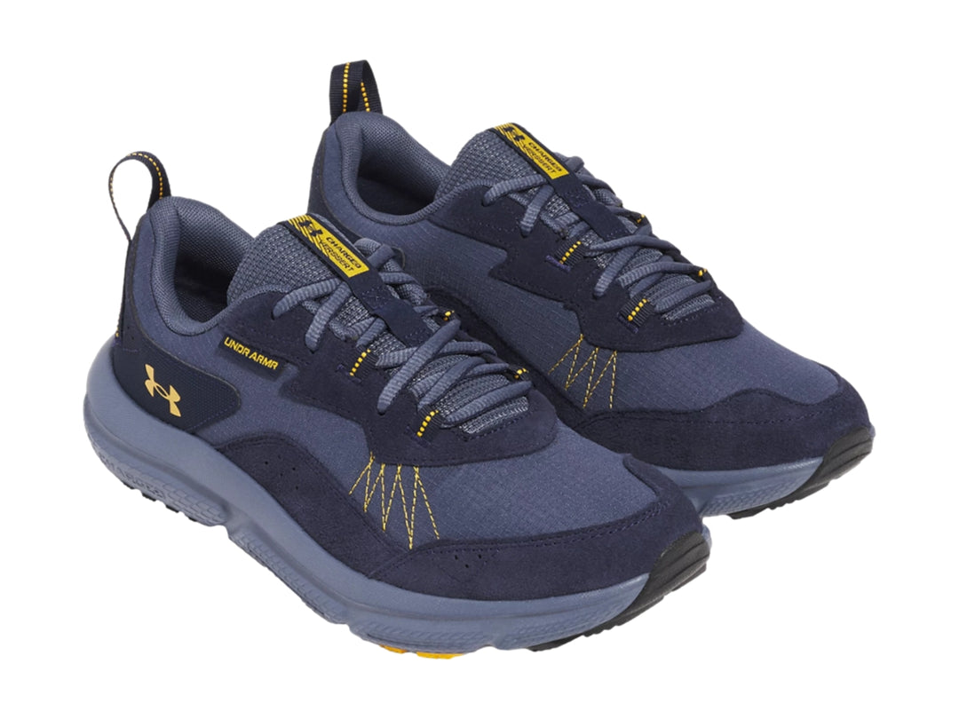 Tenis deportivos Under Armour color azul marino con detalles amarillos y suela gris.