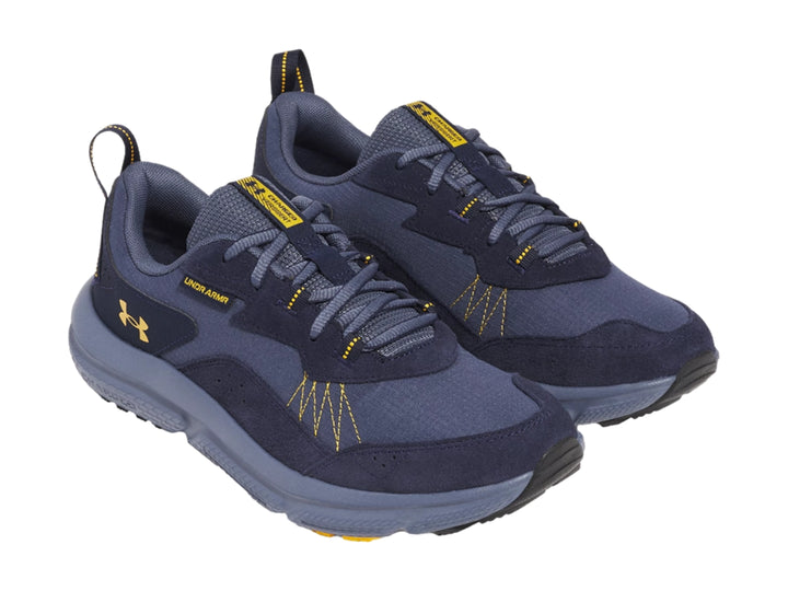 Tenis deportivos Under Armour color azul marino con detalles amarillos y suela gris.