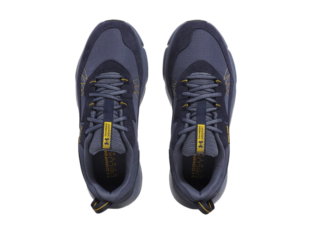 Tenis deportivos Under Armour color azul marino con detalles amarillos y suela gris.