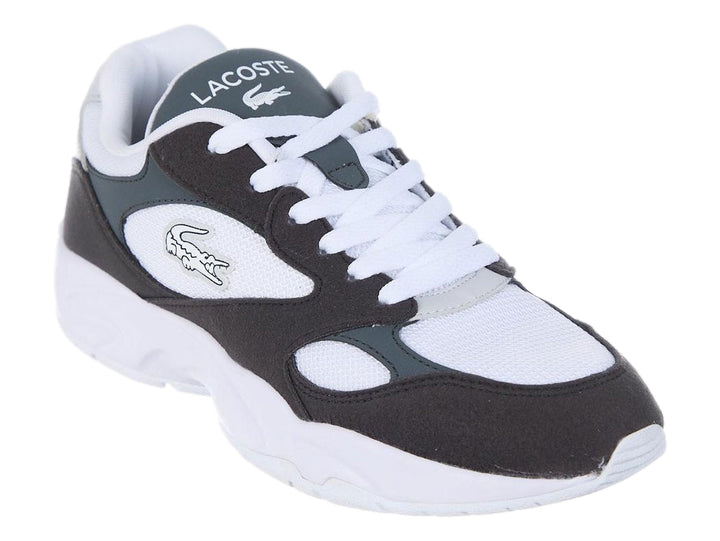 Tenis deportivos Lacoste en colores blanco, negro y gris oscuro con suela blanca gruesa.