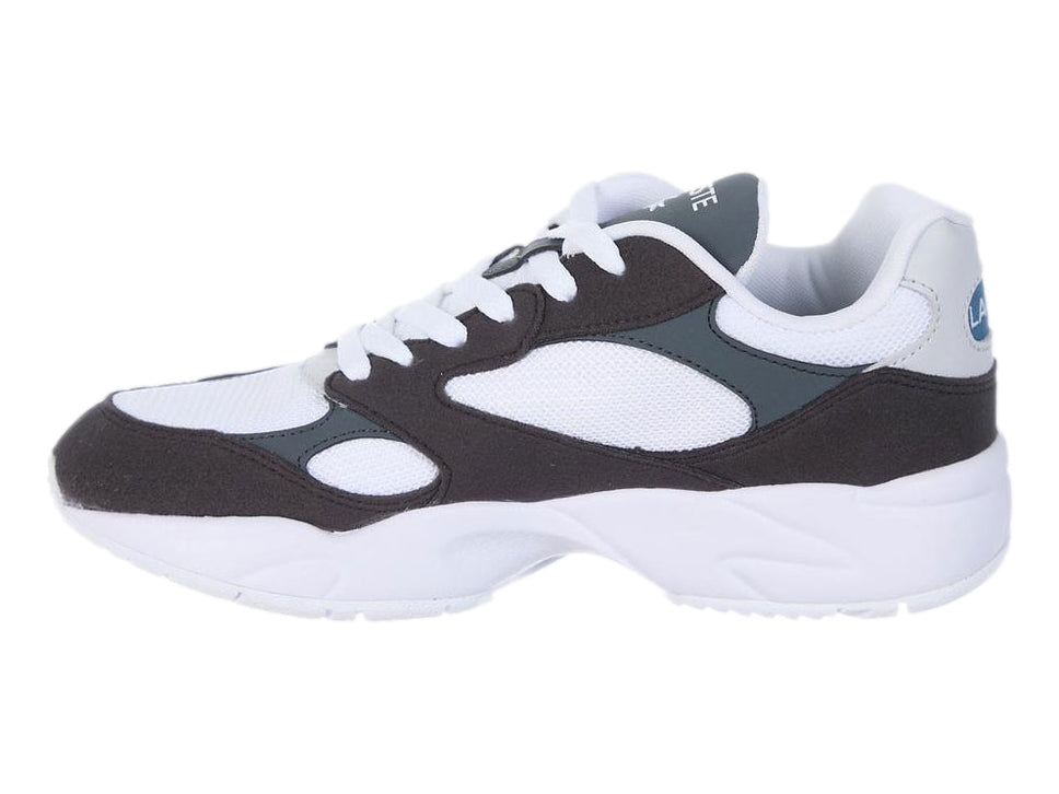 Tenis deportivos Lacoste en colores blanco, negro y gris oscuro con suela blanca gruesa.