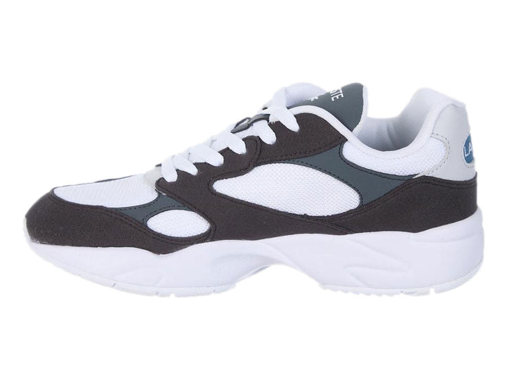 Tenis deportivos Lacoste en colores blanco, negro y gris oscuro con suela blanca gruesa.