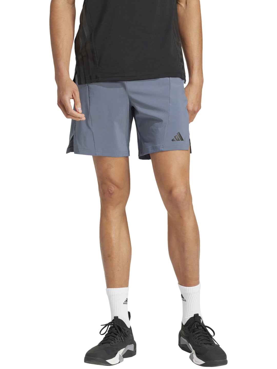 Hombre vistiendo shorts deportivos Adidas color gris onix diseñados para entrenamiento.