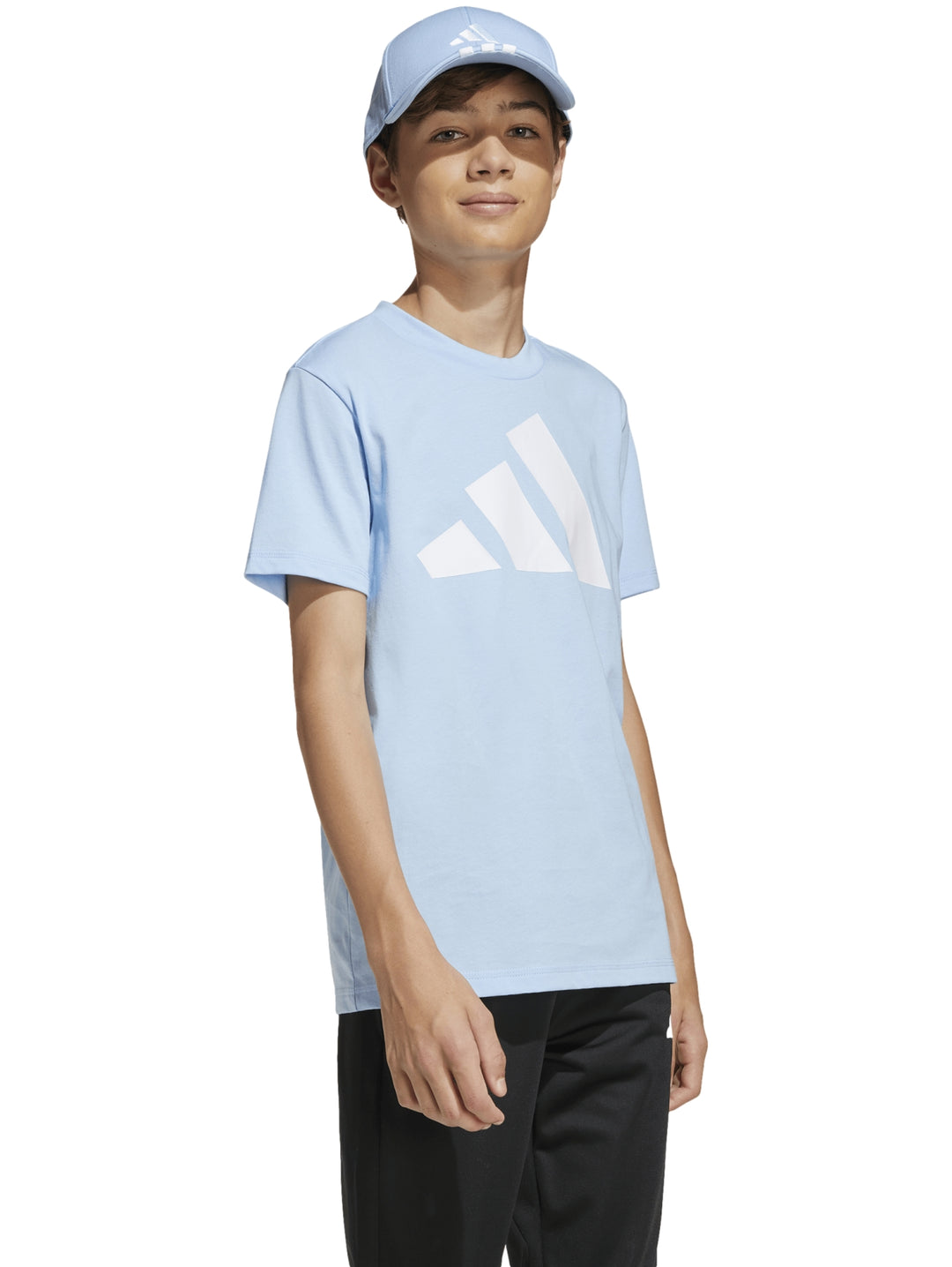 Niño vistiendo playera Adidas azul claro con detalles blancos y pantalones negros.