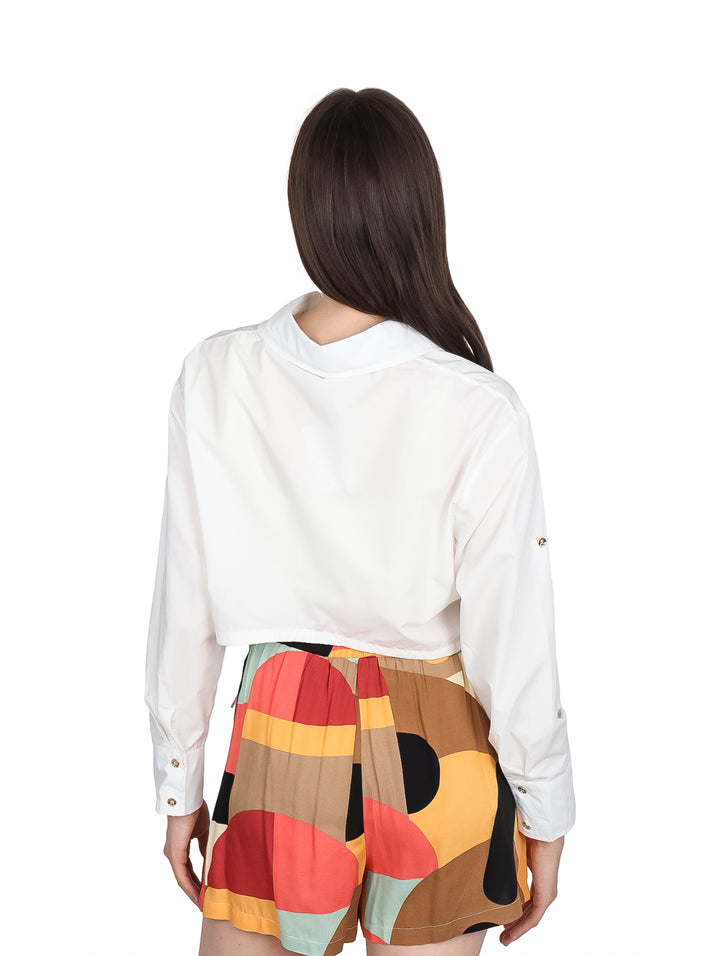 Mujer vistiendo una camisa blanca corta de manga larga con cuello.