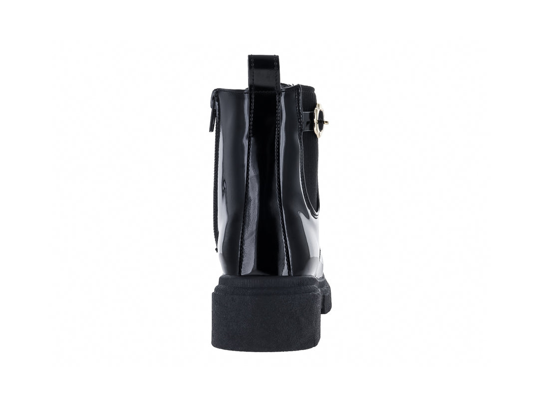 Bota negra de charol con suela de plataforma gruesa y detalles dorados.