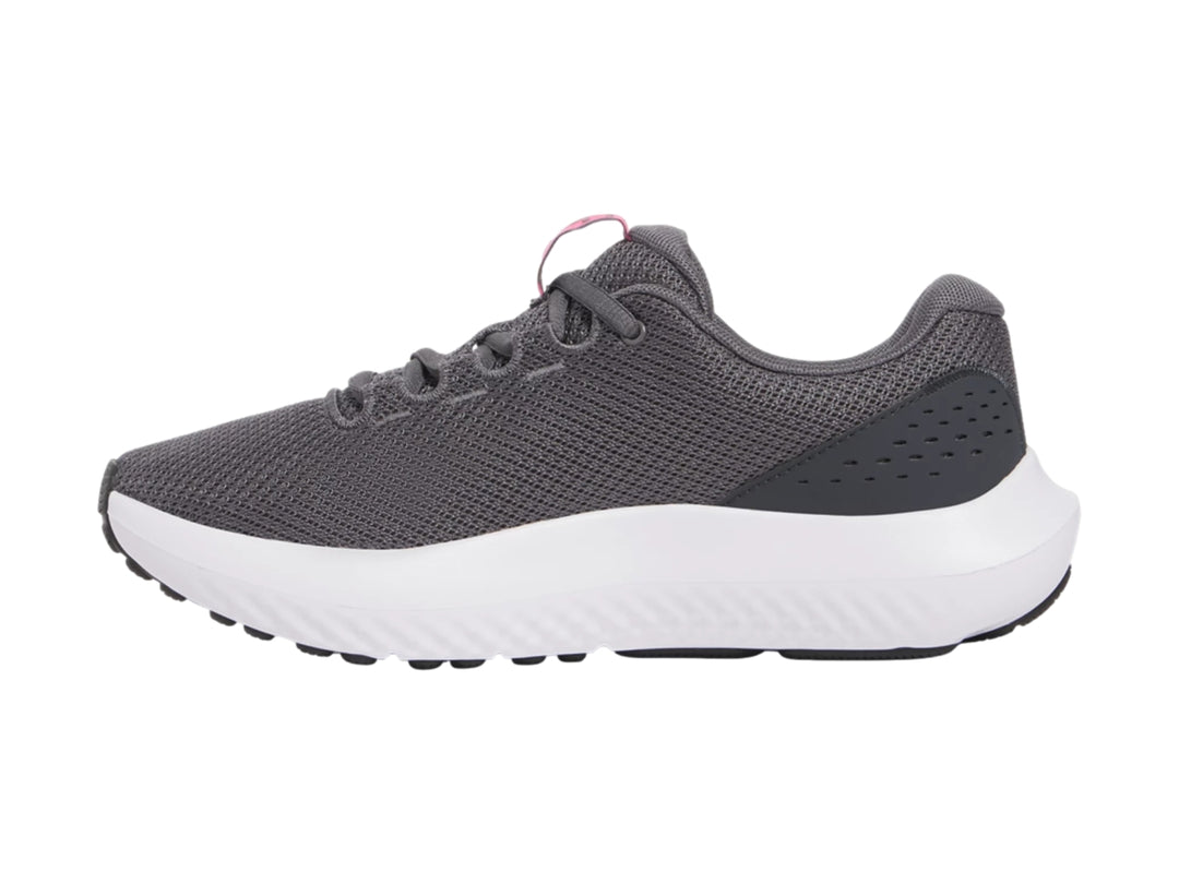 Tenis deportivos Under Armour color gris con suela blanca y logotipo rosa.