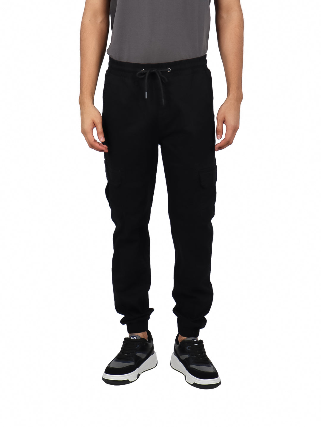 Hombre vistiendo pantalones jogger color negro con bolsillos laterales tipo cargo y puños ajustados.