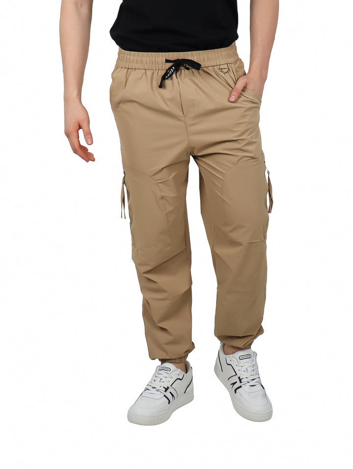 Pantalones jogger cargo color beige con cintura elástica y bolsillos laterales.