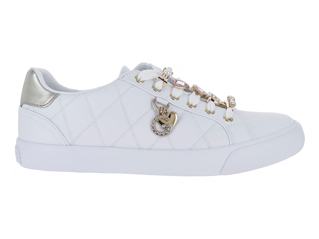 Tenis blancos para niña con textura acolchada, detalles en dorado y un dije de corazón en las agujetas.