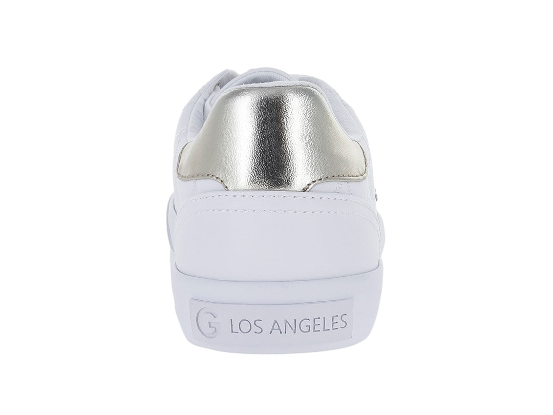 Tenis blancos para niña con textura acolchada, detalles en dorado y un dije de corazón en las agujetas.