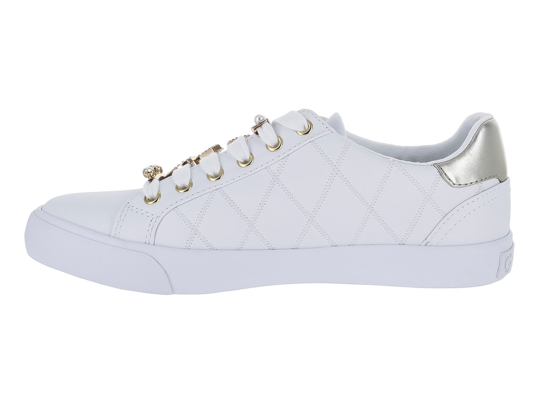 Tenis blancos para niña con textura acolchada, detalles en dorado y un dije de corazón en las agujetas.