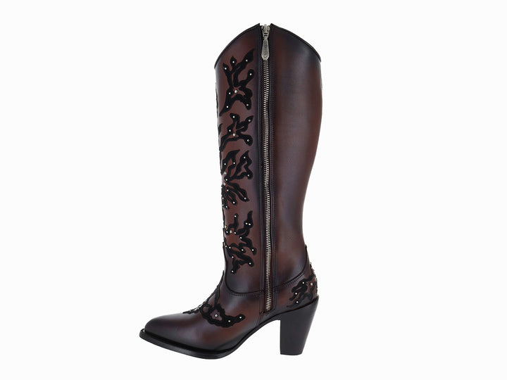 Botas vaqueras altas de cuero color chocolate con bordados negros y detalles metálicos.