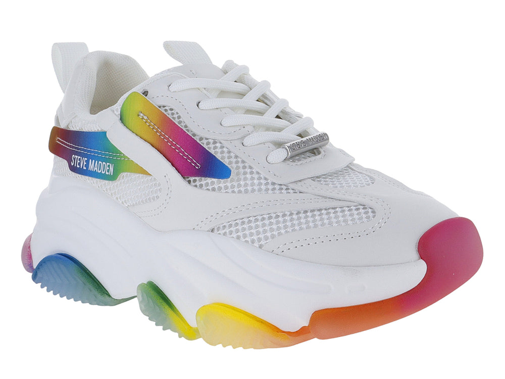 Tenis Steve Madden blancos con detalles y suela multicolor en degradado arcoíris.