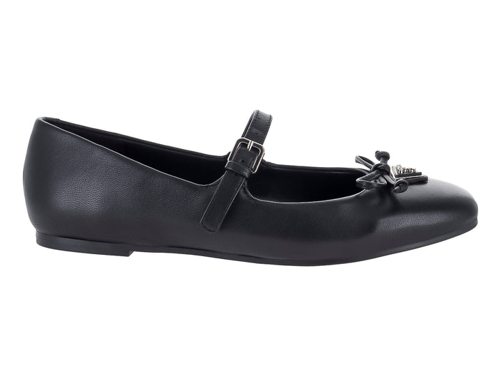 Zapato plano negro de la marca Guess con correa, hebilla y detalle de moño decorativo en la punta.