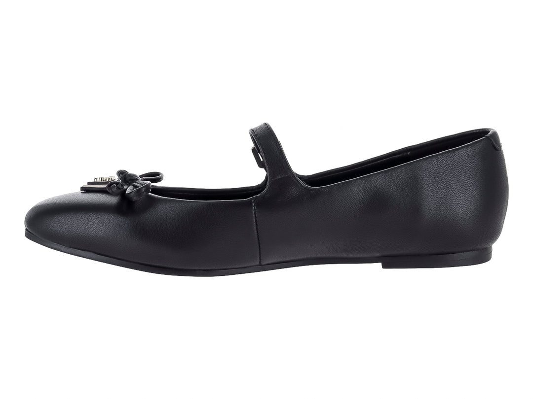 Zapato plano negro de la marca Guess con correa, hebilla y detalle de moño decorativo en la punta.