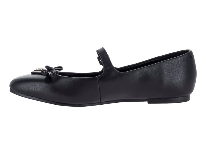 Zapato plano negro de la marca Guess con correa, hebilla y detalle de moño decorativo en la punta.