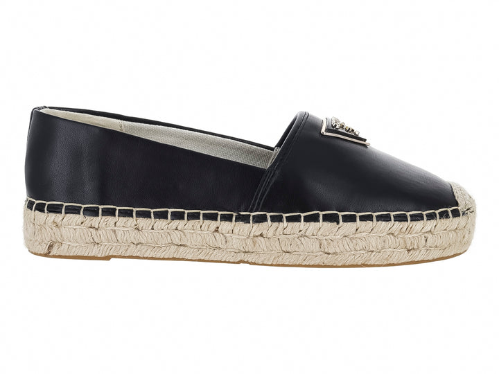 Zapato tipo alpargata color negro con suela de cuerda beige y detalle metálico en la parte superior.