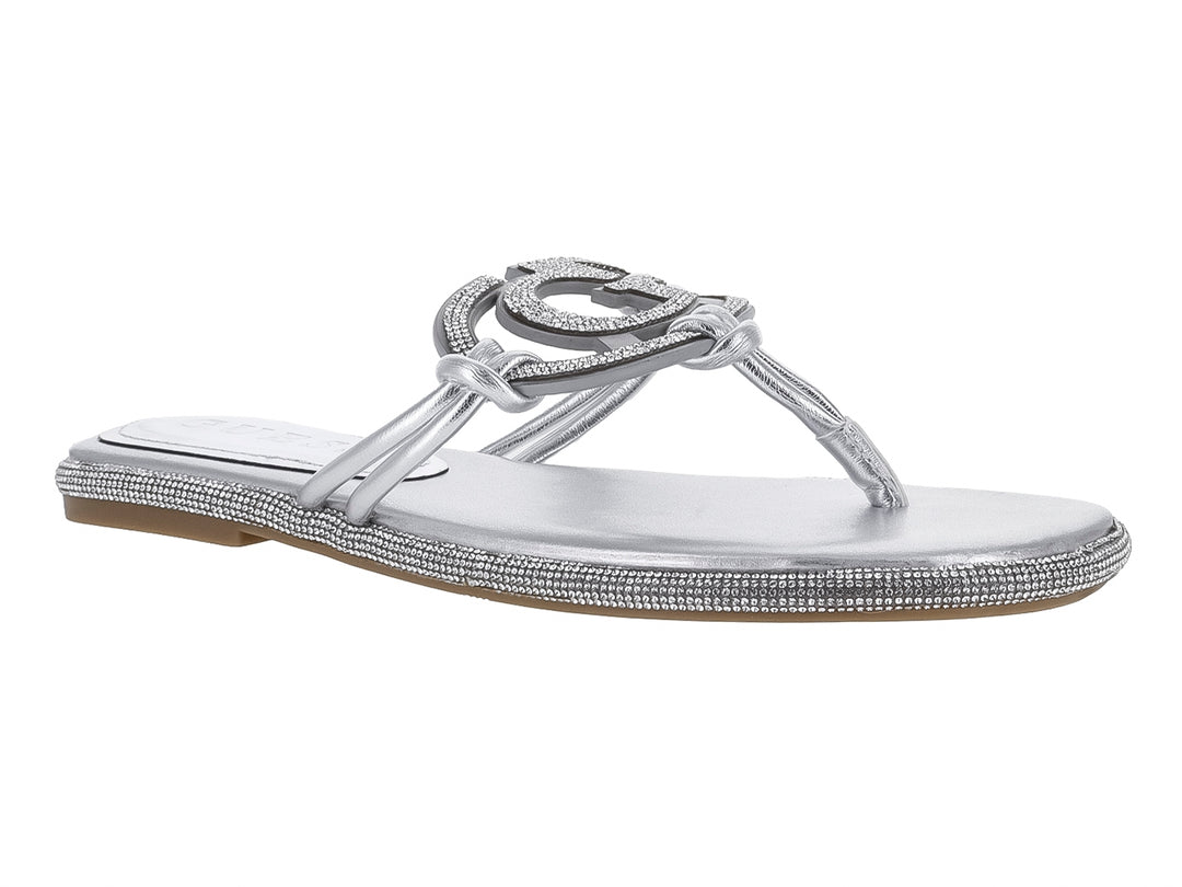 Sandalia plana color plata con detalles de pedrería y logo Guess en la correa.