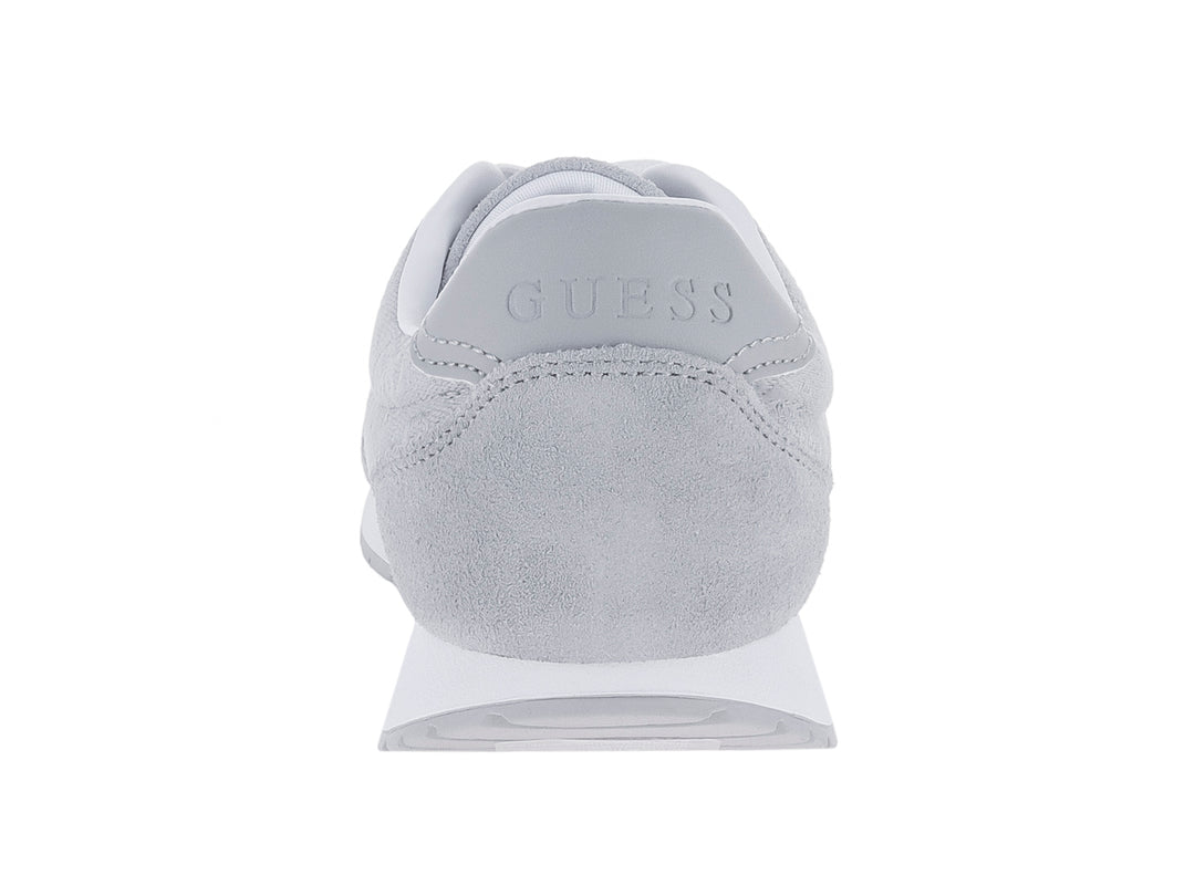 Tenis deportivos Guess color gris con suela y cordones blancos.