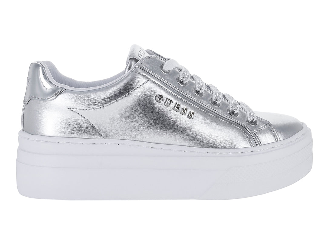 Tenis Guess color plateado metálico con suela blanca de plataforma.