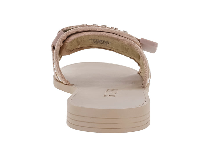 Sandalia plana GUESS color beige natural con correa ancha tejida y hebilla metálica decorativa.