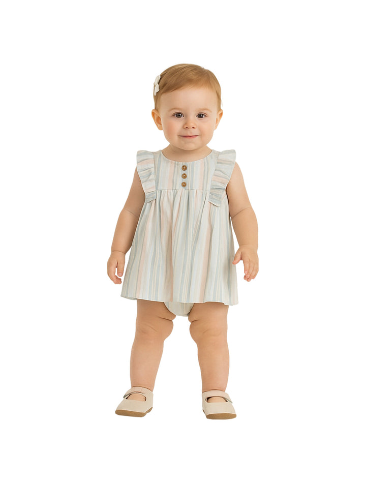 Niña pequeña vistiendo un vestido corto de rayas en tonos pastel con botones frontales y volantes en los hombros.