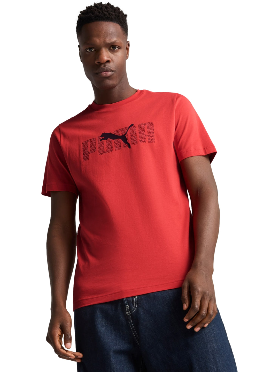 Hombre vistiendo una camiseta PUMA de color rojo fuego con logotipo negro en el pecho.