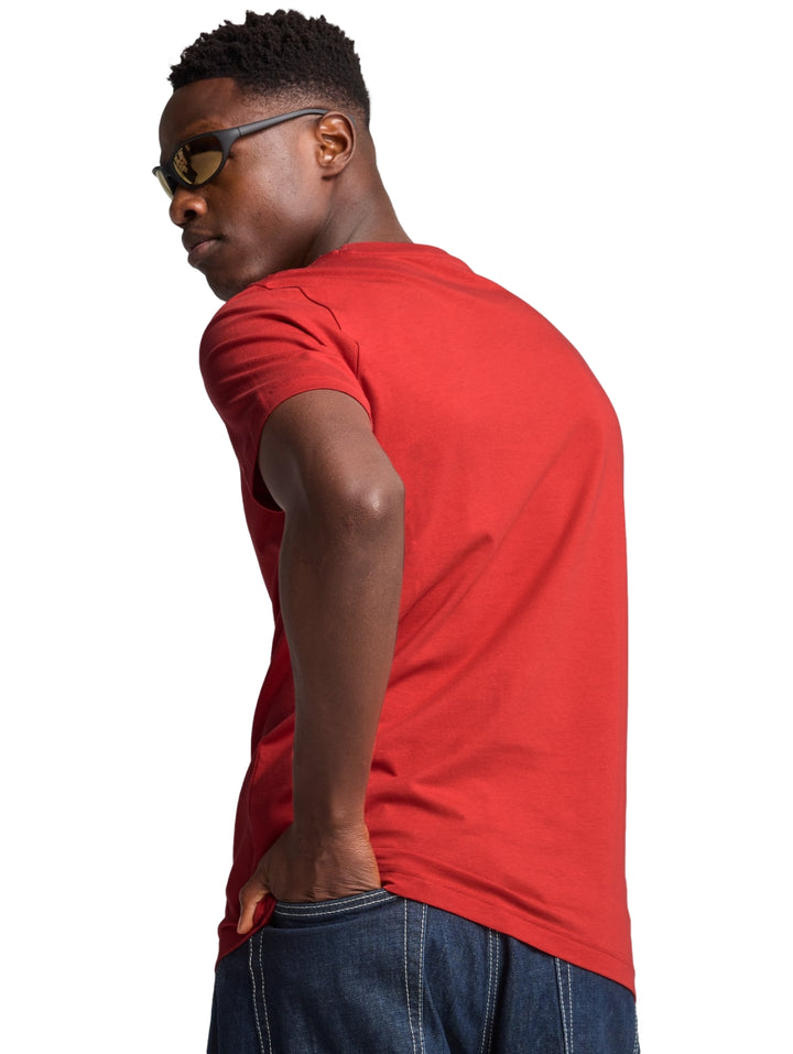 Hombre vistiendo una camiseta PUMA de color rojo fuego con logotipo negro en el pecho.