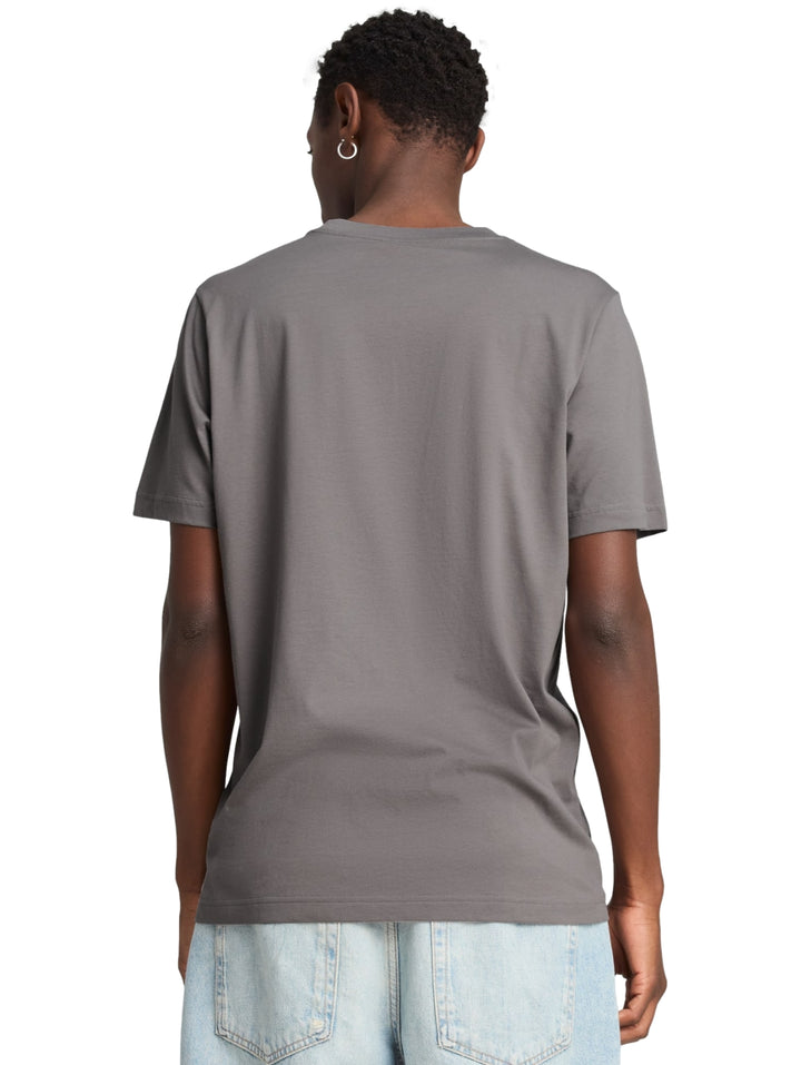 Hombre vistiendo una camiseta PUMA de color gris oscuro con logotipo en el pecho.