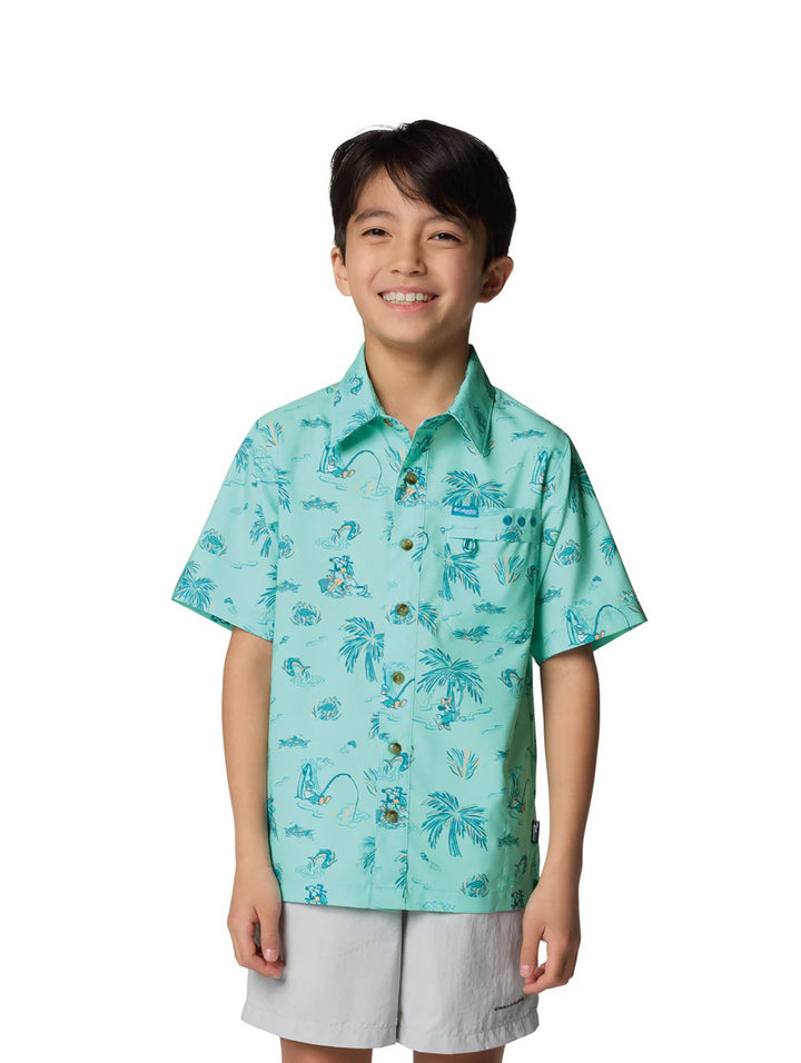 Niño vistiendo una camisa Columbia de manga corta color turquesa con estampado tropical de palmeras.