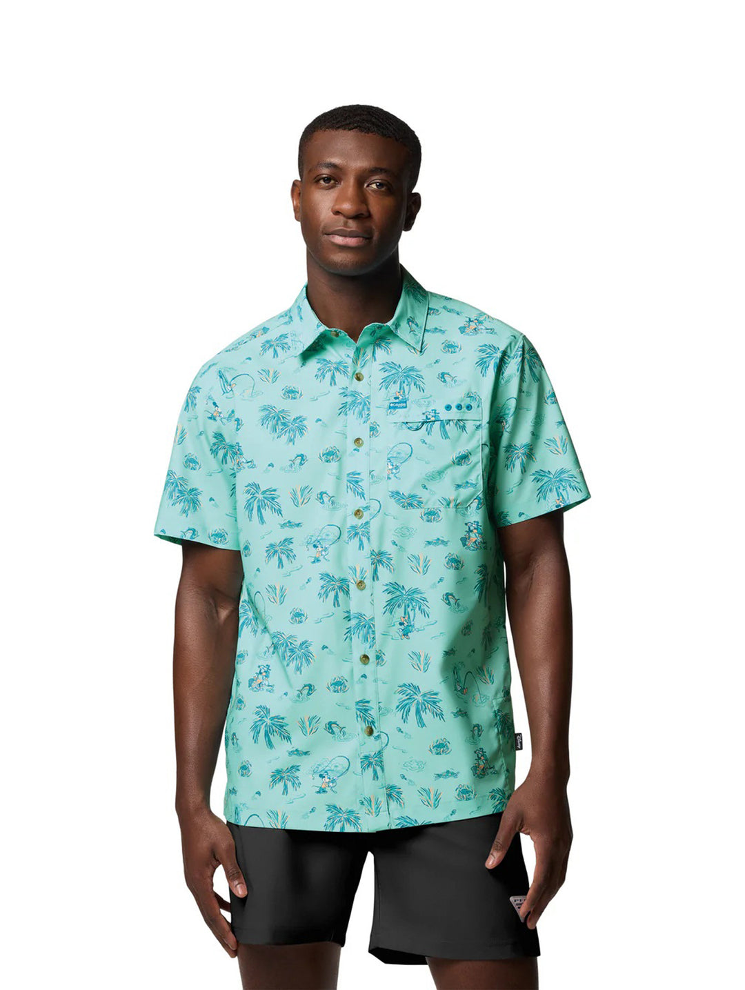 Hombre vistiendo camisa Columbia de manga corta color turquesa con estampado tropical de palmeras.