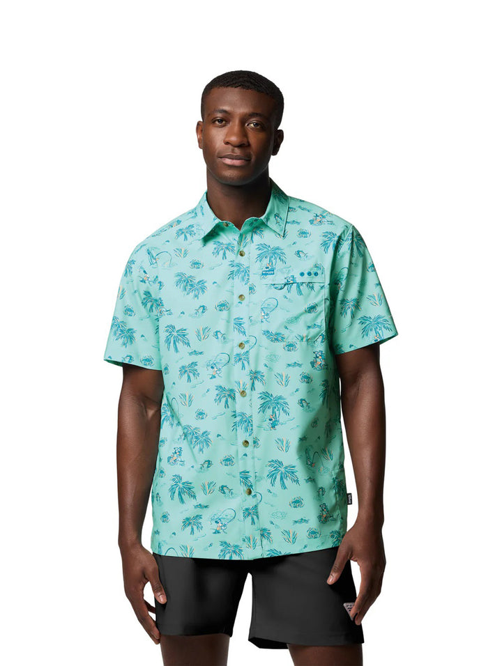 Hombre vistiendo camisa Columbia de manga corta color turquesa con estampado tropical de palmeras.