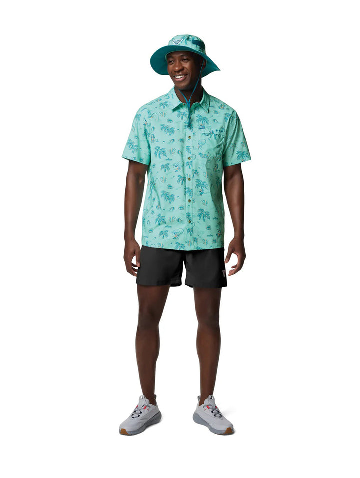 Hombre vistiendo camisa Columbia de manga corta color turquesa con estampado tropical de palmeras.
