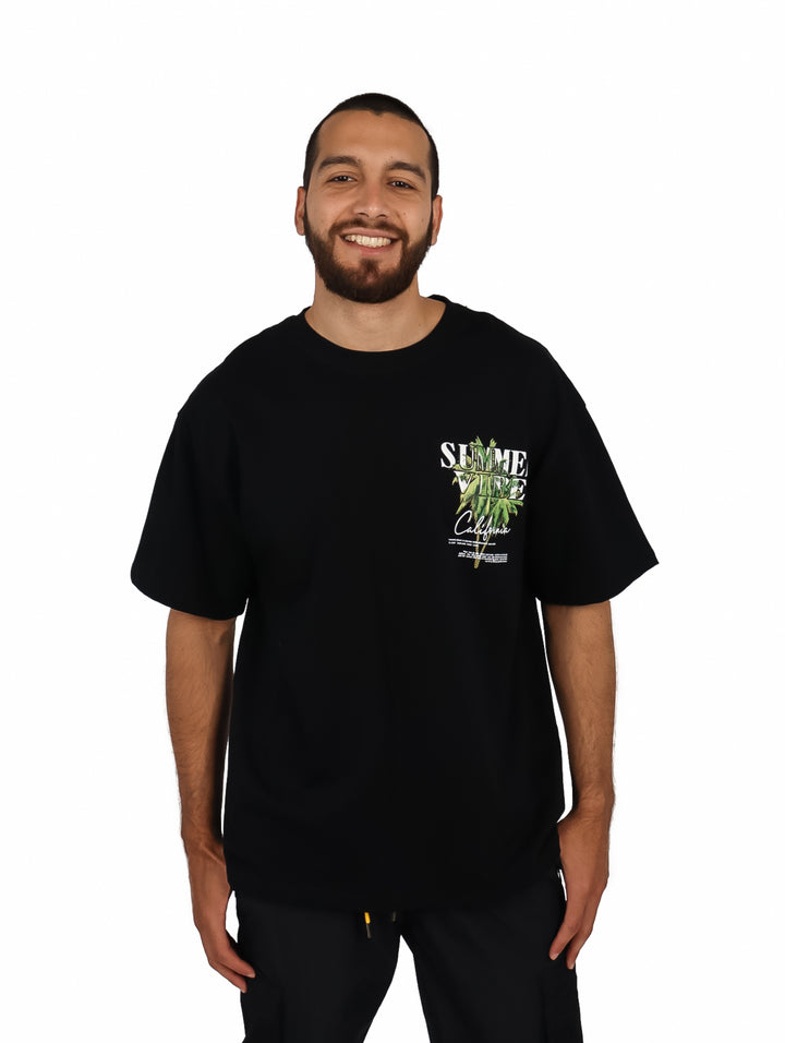Hombre vistiendo una playera negra de manga corta con un estampado gráfico en el pecho.