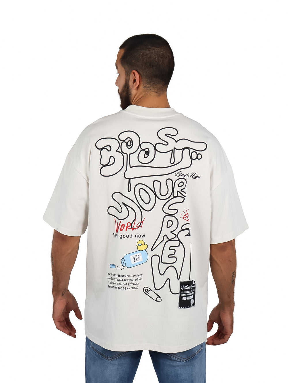 Hombre vistiendo playera oversize color arena con logo en el pecho.