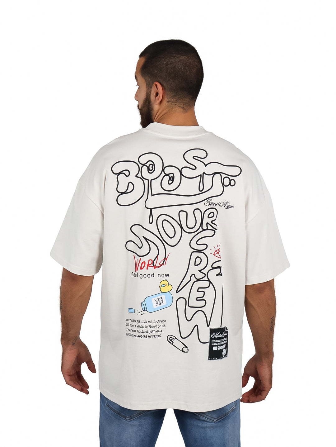 Hombre vistiendo playera oversize color arena con logo en el pecho.