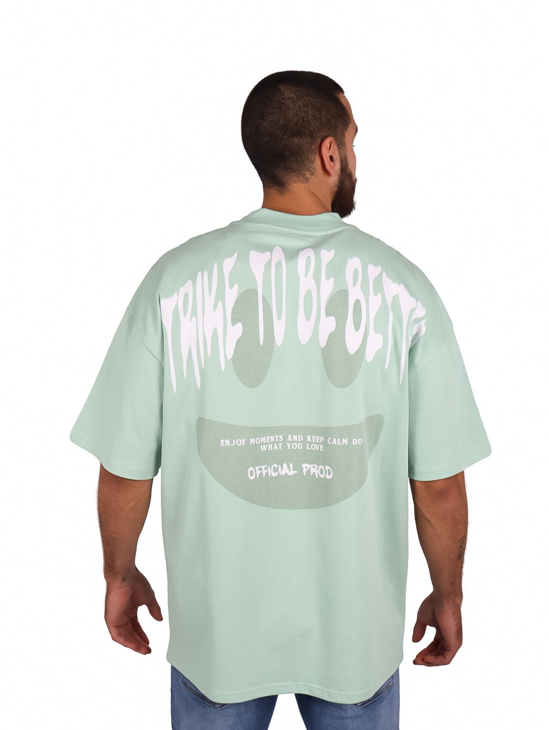 Hombre vistiendo una playera oversize de color menta con logo blanco en el pecho.