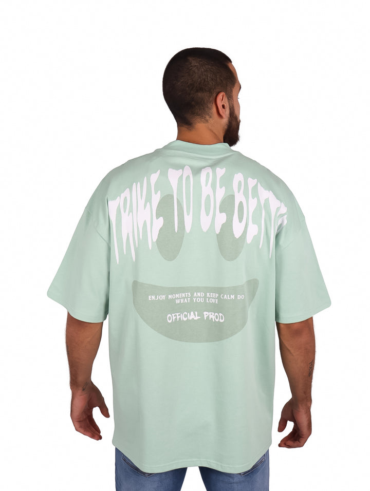 Hombre vistiendo una playera oversize de color menta con logo blanco en el pecho.