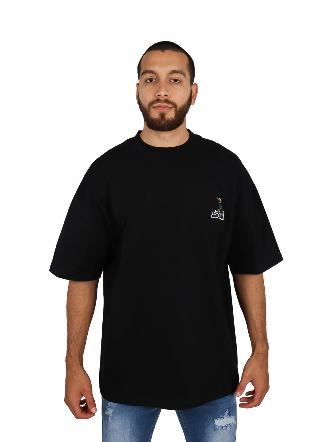 Hombre vistiendo playera oversize color negro de manga corta con un pequeño logo en el pecho.