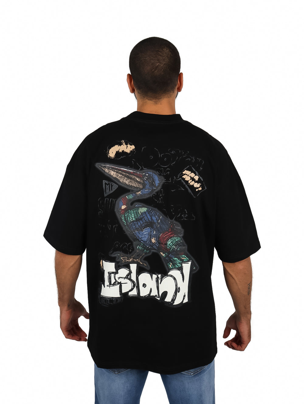 Hombre vistiendo playera oversize color negro de manga corta con un pequeño logo en el pecho.