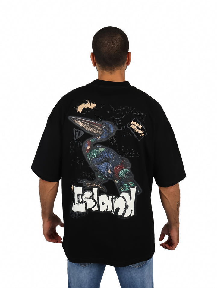 Hombre vistiendo playera oversize color negro de manga corta con un pequeño logo en el pecho.