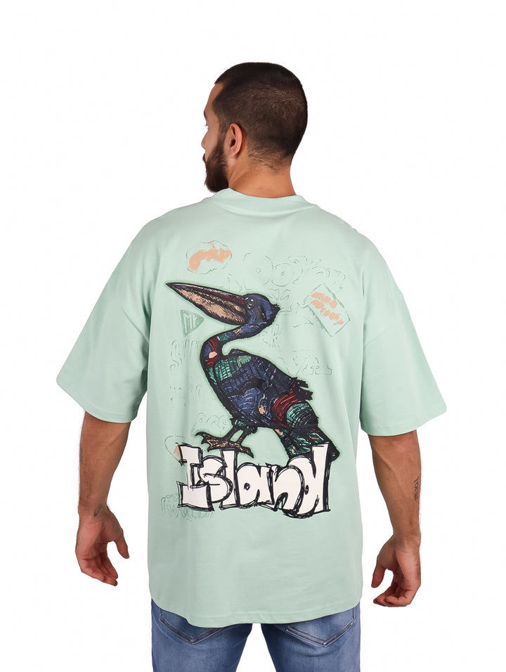 Hombre vistiendo playera oversize color menta de manga corta con un pequeño logo en el pecho.